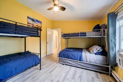 two bunk beds in a room with yellow walls at Catskills Lakefront with Hot Tub, Sauna and Theater in Monticello