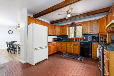 a kitchen with wooden cabinets and a white refrigerator at Enola Trail Getaway - bikes, rural, BBQ ,King bed, patio in Pequea