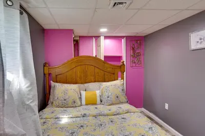 a bed in a room with pink and purple walls at 9 Mi to Midtown Convenient Harrisburg Apt in Harrisburg