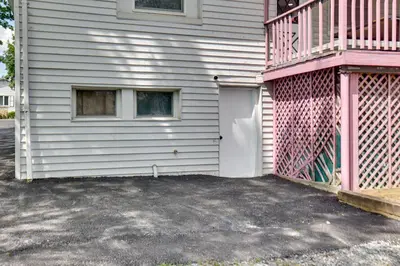a white house with a pink door and a balcony at 9 Mi to Midtown Convenient Harrisburg Apt in Harrisburg