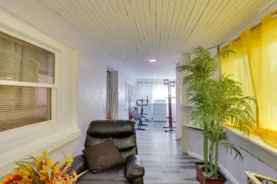 a living room with a leather chair and plants at 9 Mi to Hersheypark Spacious Home with Deck in Harrisburg