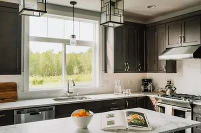 a kitchen with black cabinets and a sink and a window at Elevated Catskills Getaway On 15-acre Private Farm in Parksville