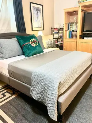 a bedroom with a large bed with a green pillow at Welcome to Grande Lux - Boutique Hotel Style- 20 mins to NYC Times Square in Englewood