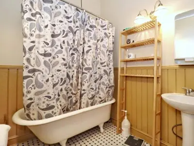 a bathroom with a tub and a shower curtain at Yard, Laundry, Large! Bonus Sleep Area in Jersey City