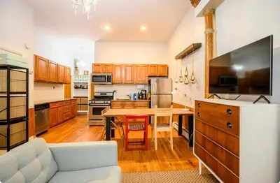 a large kitchen with a table and a couch at Yard, Laundry, Large! Bonus Sleep Area in Jersey City