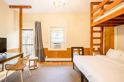 a bedroom with a bed and a desk and a window at Yard, Laundry, Large! Bonus Sleep Area in Jersey City