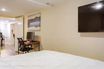 a bedroom with a bed and a desk and a television at Staycation Suite in Philadelphia
