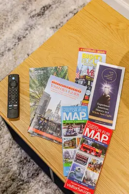 a table with magazines and a remote control on it at Staycation Suite in Philadelphia