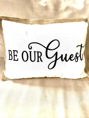 a white pillow with the words be our guest at Masthope Heritage Chalet in Lackawaxen