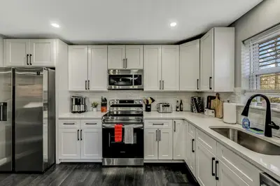 a kitchen with white cabinets and stainless steel appliances at Leisurely Living in Long Pond in Long Pond