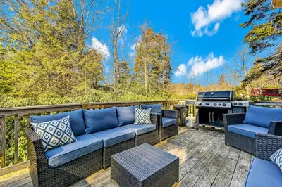 a patio with a couch and a grill on a deck at Leisurely Living in Long Pond in Long Pond