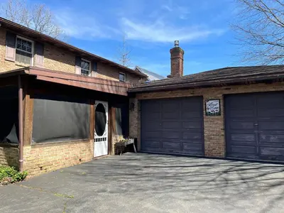 a brick house with two garage doors and a driveway at Spacious Antique Charm Home by Leavetown Vacations in Columbia