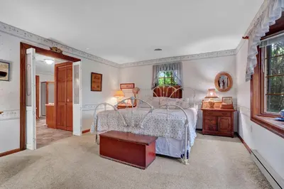 a bedroom with a bed with a table and a window at Spacious Antique Charm Home by Leavetown Vacations in Columbia