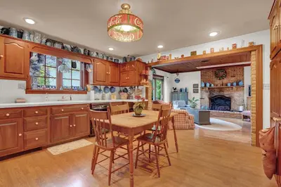 a kitchen with wooden cabinets and a table with chairs at Spacious Antique Charm Home by Leavetown Vacations in Columbia