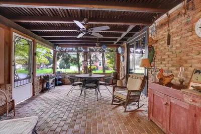 a screened in porch with a ceiling fan and a table at Spacious Antique Charm Home by Leavetown Vacations in Columbia