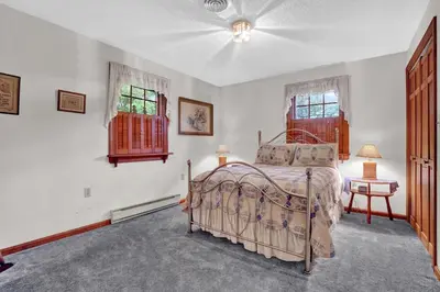a bedroom with a bed and two windows at Spacious Antique Charm Home by Leavetown Vacations in Columbia