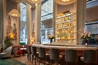 a bar in a restaurant with a large window at The Wall Street Hotel by Suiteness in New York