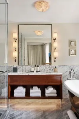 a bathroom with a sink and a large mirror at The Wall Street Hotel by Suiteness in New York