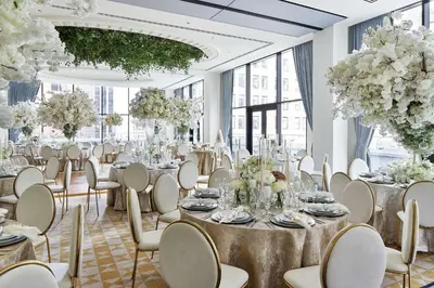 a banquet hall with tables and chairs and flowers at The Wall Street Hotel by Suiteness in New York