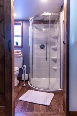 a bathroom with a glass shower with a toilet at Cozy Cabin Gateway with Pool and Firepit in Montgomery