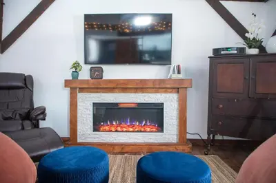a living room with a fireplace with a tv at Cozy Cabin Gateway with Pool and Firepit in Montgomery