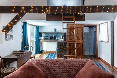 a living room with a loft bed with lights at Cozy Cabin Gateway with Pool and Firepit in Montgomery