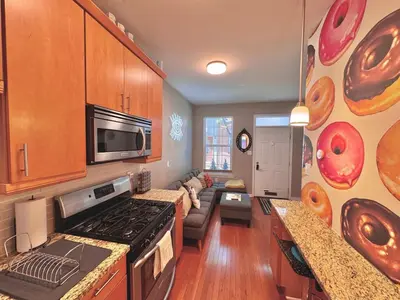 a kitchen with a living room with donuts on the wall at Modern-Chic Living in the Heart of Center City in Philadelphia