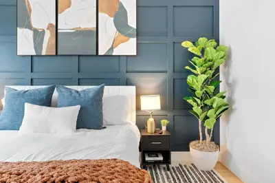 a bedroom with blue walls and a bed with a plant at Luxury 3BR Backyard Oasis Close to NYC FirePit in Jersey City