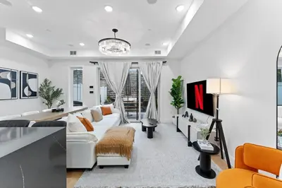 a living room with a white couch and chairs at Luxury 3BR Backyard Oasis Close to NYC FirePit in Jersey City