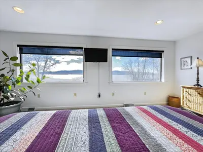 a bedroom with a large bed and two windows at Susquehanna Riverside Condo by Leavetown Vacations in Columbia