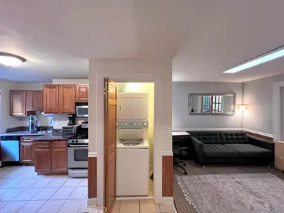 a kitchen and a living room with a couch at Ten Minute Commute to NYC in Jersey City
