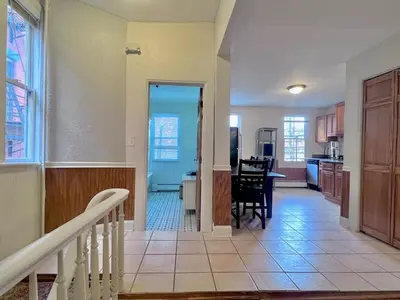 a kitchen and living room with a staircase and a dining room at Ten Minute Commute to NYC in Jersey City