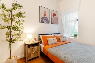 a bedroom with an orange bed and a plant at Aura Style 3BD Suite at Times Square Manhattan in New York