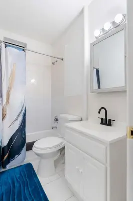 a white bathroom with a toilet and a sink at Aura Style 3BD Suite at Times Square Manhattan in New York