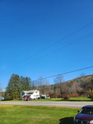 a car parked on a road next to a house at 2BR in Peaceful Country Near Ithaca in Willseyville