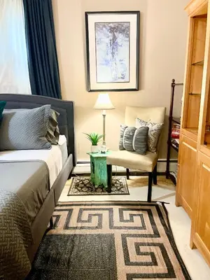 a living room with a bed and a chair at Grande Lux Room- Boutique Hotel Style-15mins to NYC in Englewood