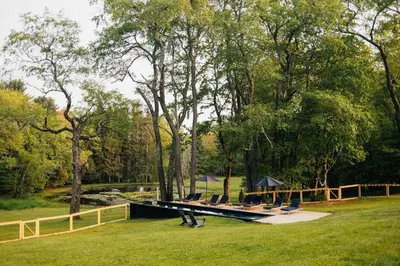 a group of chairs sitting on a dock in the grass at Coop 003 in Kenoza Lake