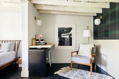 a living room with a chair and a bed at Coop 003 in Kenoza Lake