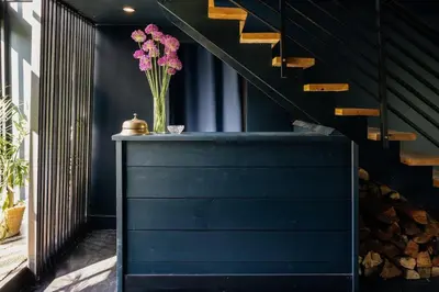 a vase of pink flowers on a table next to a staircase at Suite 001 in Kenoza Lake