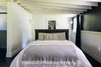 a bedroom with a large bed with a wooden headboard at Suite 001 in Kenoza Lake