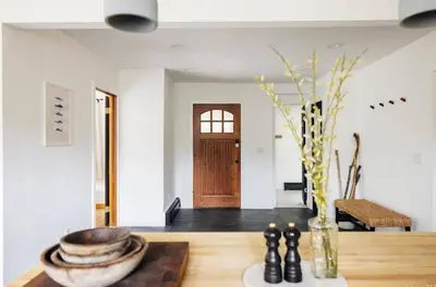 a living room with a table with a vase and a vase at Catskills ChestnutCreek+Swimming Hole+Firepit+Hike in Neversink