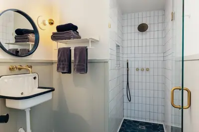 a bathroom with a shower and a sink and a mirror at FOUNDERS COTTAGE - 2 room with kitchennete in Kenoza Lake
