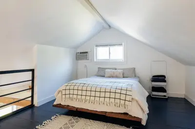 a white bedroom with a bed and a window at FOUNDERS COTTAGE - 2 room with kitchennete in Kenoza Lake