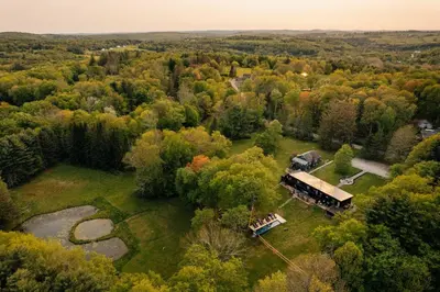 an aerial view of a house in the woods at FOUNDERS COTTAGE - 2 room with kitchennete in Kenoza Lake