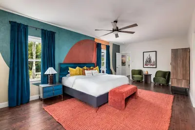 a bedroom with a large bed and a red rug at The Poconest - Luxurious Mountain Mansion in Long Pond