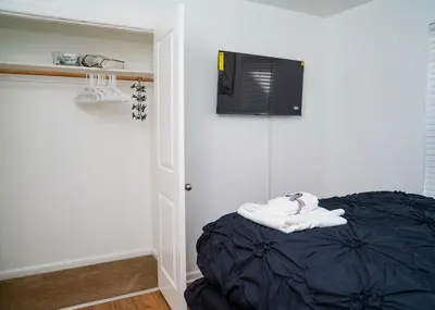 a room with a bed with a tv on the wall at Anike's Place in Newark