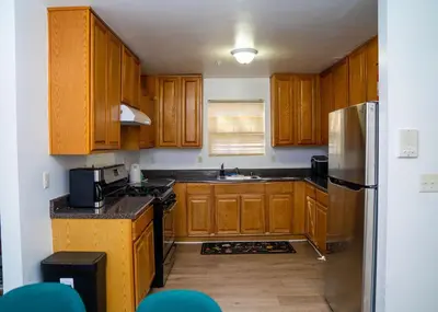 a kitchen with wooden cabinets and a stainless steel refrigerator at Anike's Place in Newark