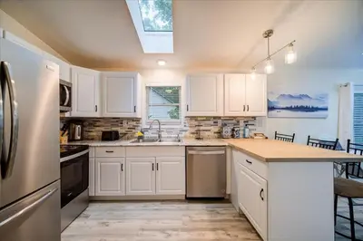 a kitchen with white cabinets and a counter top at Catskills Lakefront with Hot Tub, Sauna and Theater in Monticello