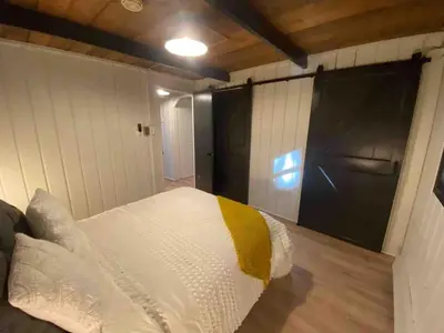 a bedroom with a white bed with a yellow blanket at Cozy Cottage 1 Block Walk From Lake Naomi - Poconos Pennsylvania Area 2 hours from New York City or Philadelphia - Pets Welcome - Check Minimum Night Requirement in Pocono Pines