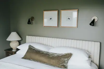 a bedroom with a white bed with two pictures on the wall at Luxury Cabin at Beaver Creek with hot tub and stunning views in Strasburg